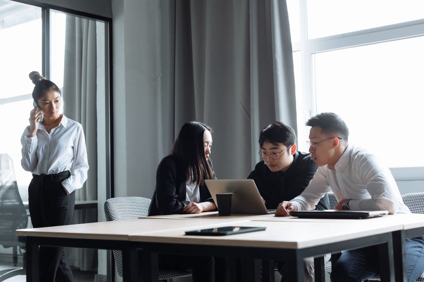 Professionals discussing work together around a laptop